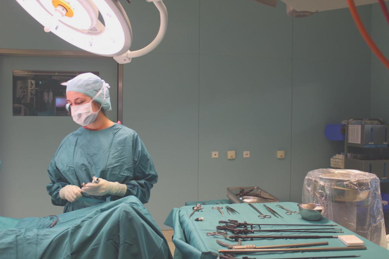 Eine Operationstechnische Assistentin und ein Patient auf einem Operationstisch